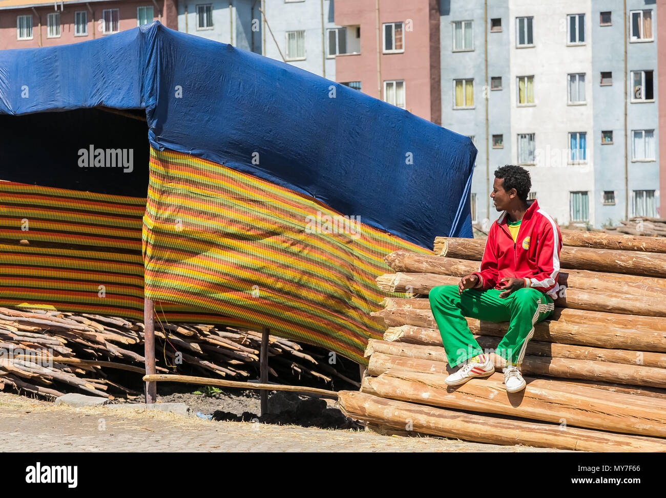 Etiopia ad Addis Abeba, 30 gennaio 2014, uomo seduto su una pila di impalcatura di legno tavole Foto Stock