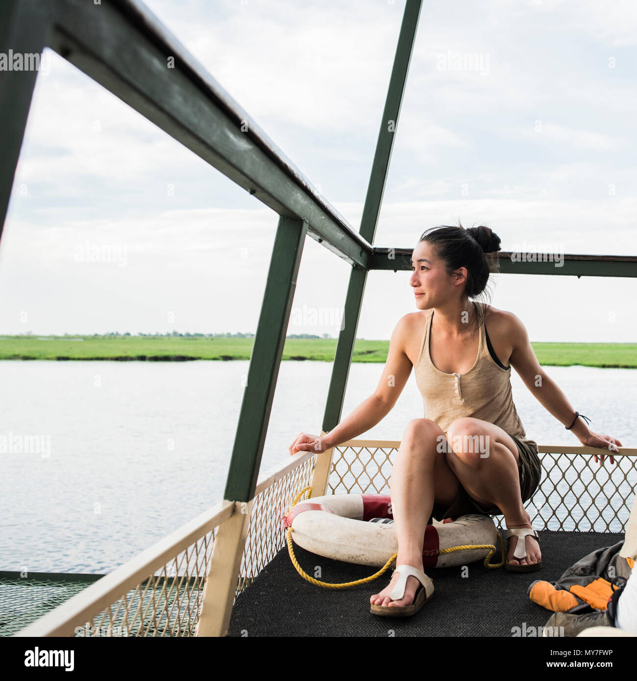 Giovane turista femminile sul fiume Chobe tour in barca, Botswana, Africa Foto Stock