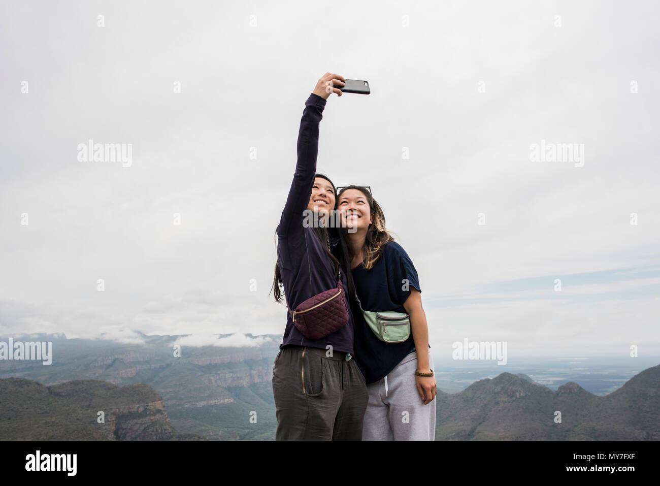 Due giovani turisti femmina tenendo selfie dai tre Rondavels, Mpumalanga, Sud Africa Foto Stock