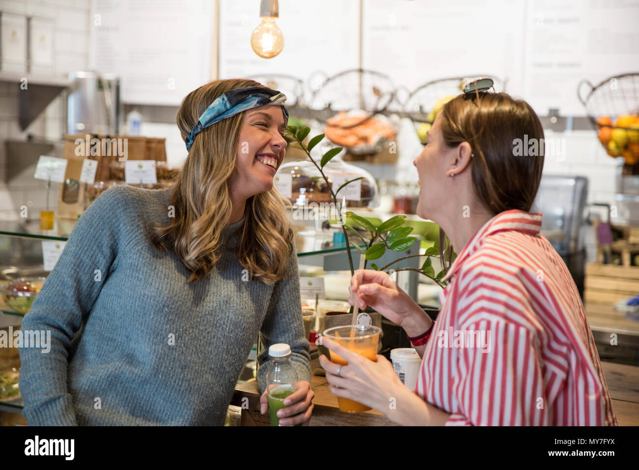 Due giovani amici di sesso femminile ridere insieme al cafe Foto Stock