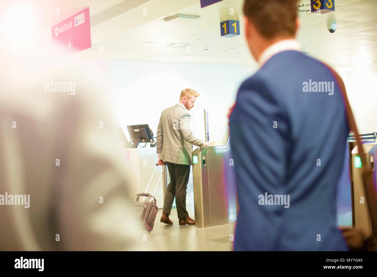 Uomo che cammina attraverso il cancello di sicurezza all'aeroporto Foto Stock