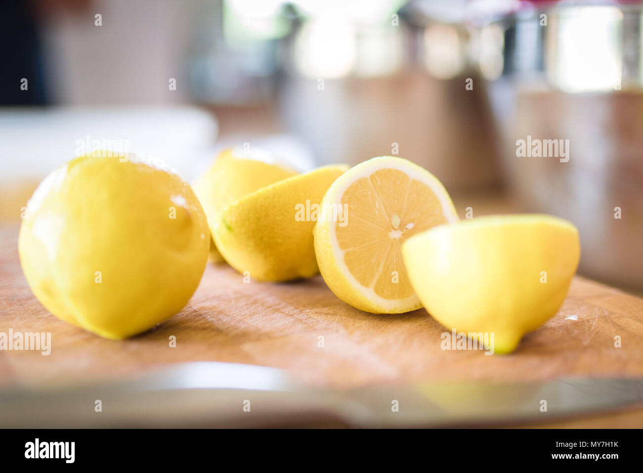 Limoni tagliati su di un tagliere in una luminosa ariosa cucina Foto Stock