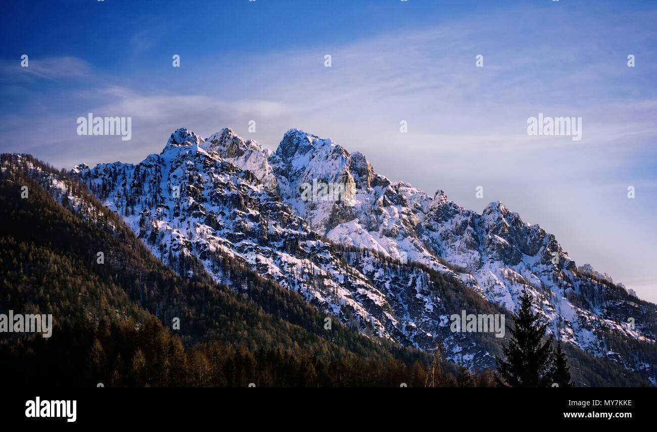 Picco di montagna circondato da nuvole, Skrlatica montagna nel bagliore di sera Foto Stock