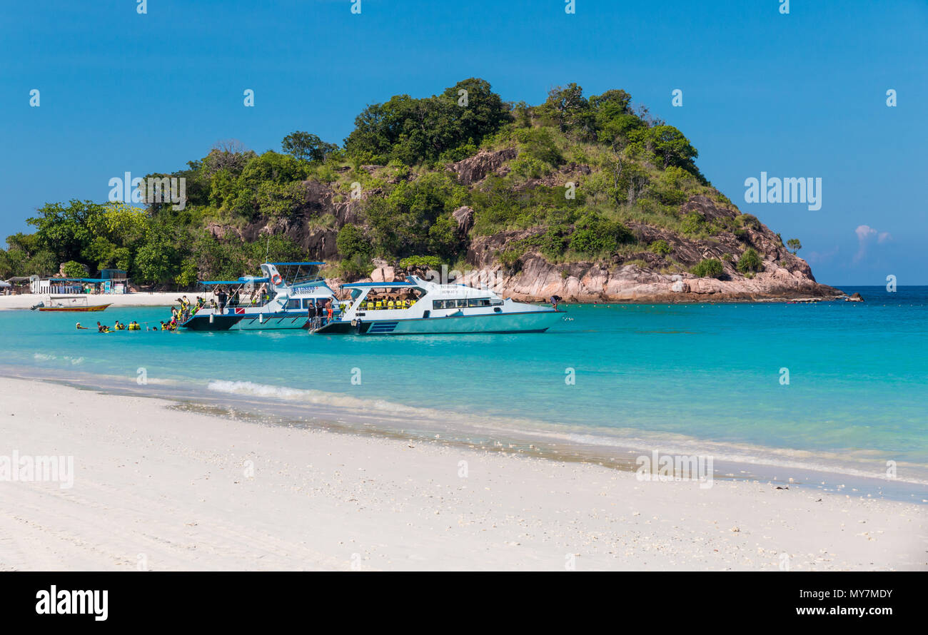 I turisti con giallo giubbotti di salvataggio sono sempre al di fuori di un'imbarcazione a motore nell'acqua turchese presso la bella sabbia bianca lunga spiaggia (Pasir Panjang Foto Stock