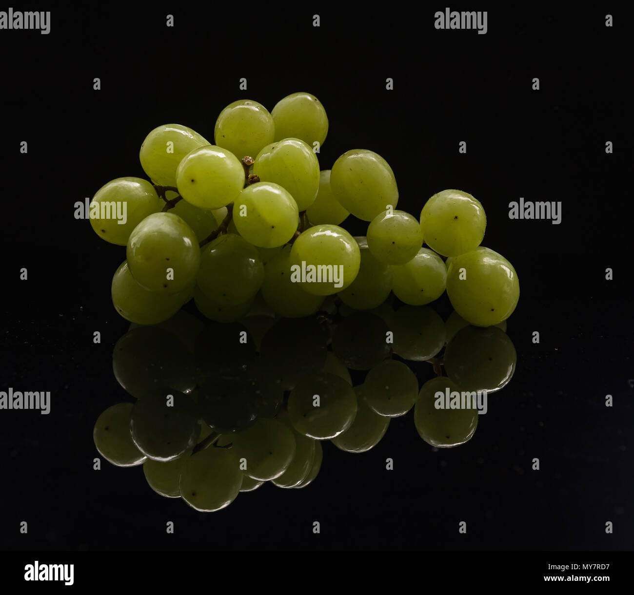 Un grappolo di uva bianca con una riflessione in un basso formato chiave Foto Stock