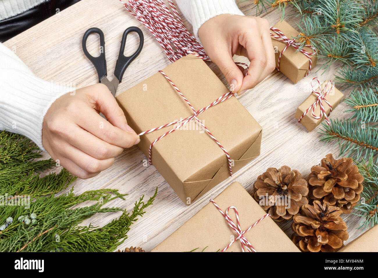 Regali di natale preparazione. Confezione regalo avvolto in bianco e nero a  strisce di carta, una cassa piena di pigne e giocattoli di Natale e  materiale di incarto Foto stock - Alamy