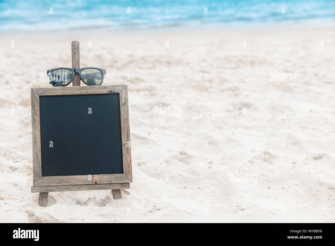 Chalk board con gli occhiali da sole sul mare spiaggia di sabbia estate tropic Foto Stock
