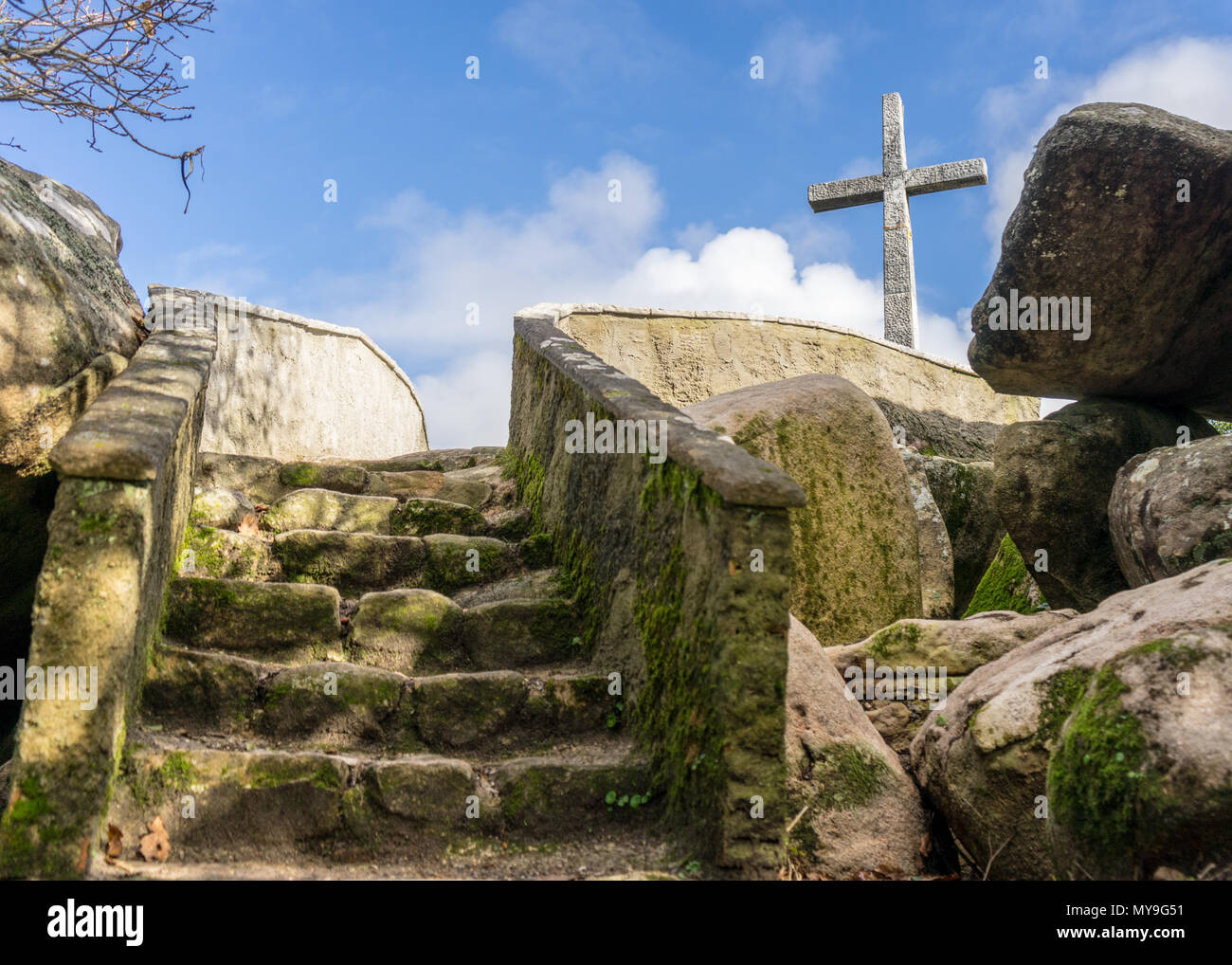 Croce sulla cima di una collina vicino a Capela de Santa Eufémia, Sintra Portogallo. Le scale conducono ad un plattform al di sotto di un soleggiato, cielo blu. Foto Stock