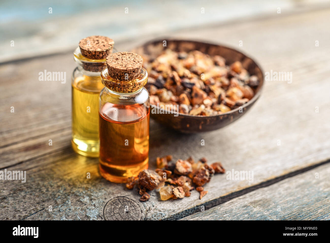 Una bottiglia di mirra olio essenziale di mirra resina su uno sfondo di legno Foto Stock