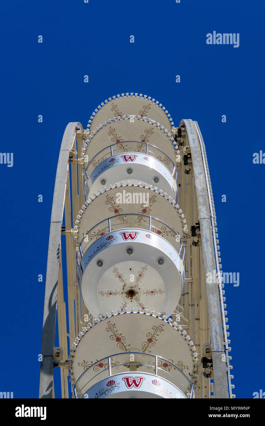 Vista astratta dal lato di una ruota panoramica Ferris con gondole bianco ad una fiera senza passeggeri in auto davanti a un cielo blu, germnay Foto Stock