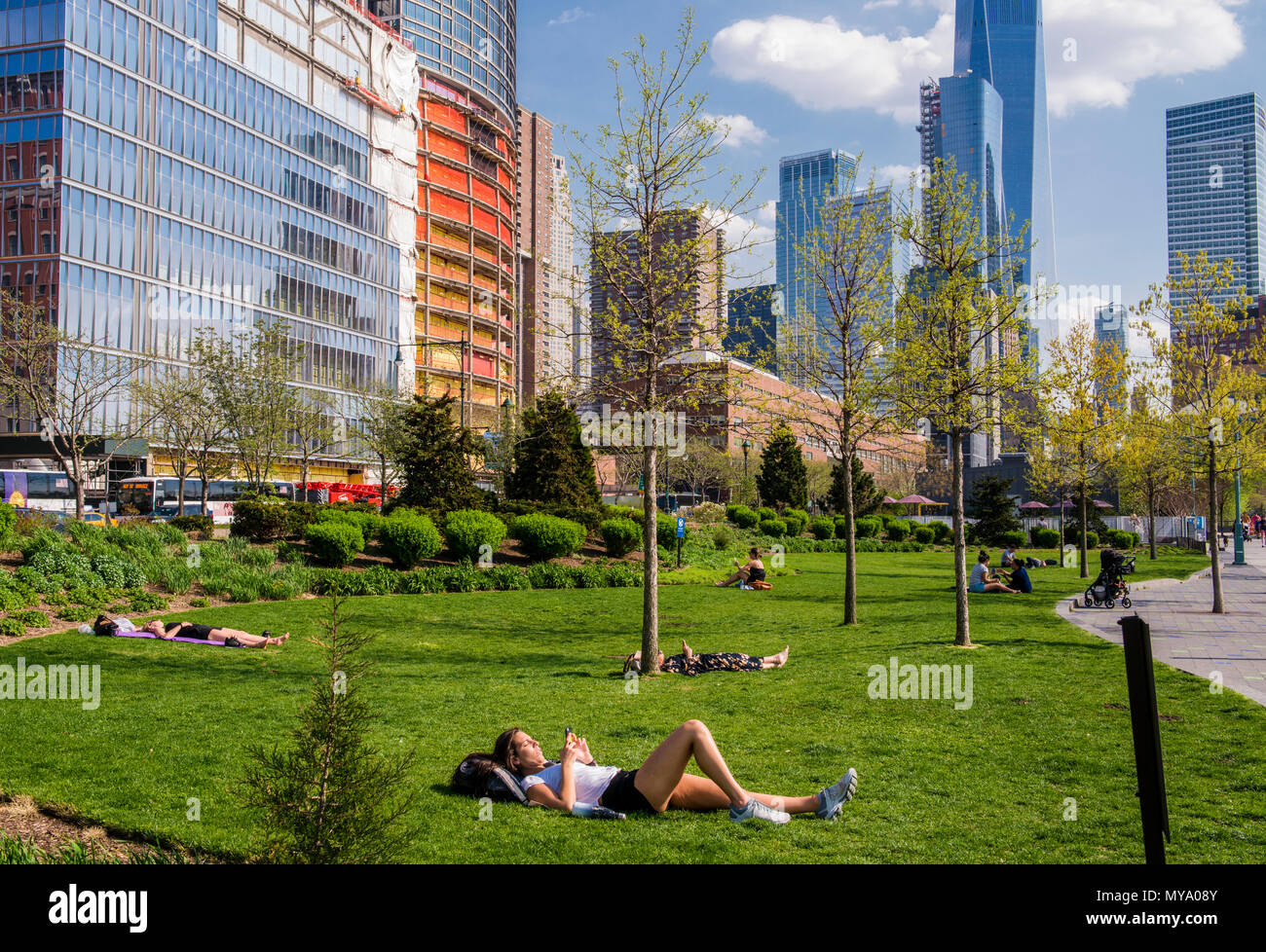 Persone relax su erba in Lower Manhattan, One World Trade Center building.in background, New York City, Stati Uniti d'America Foto Stock