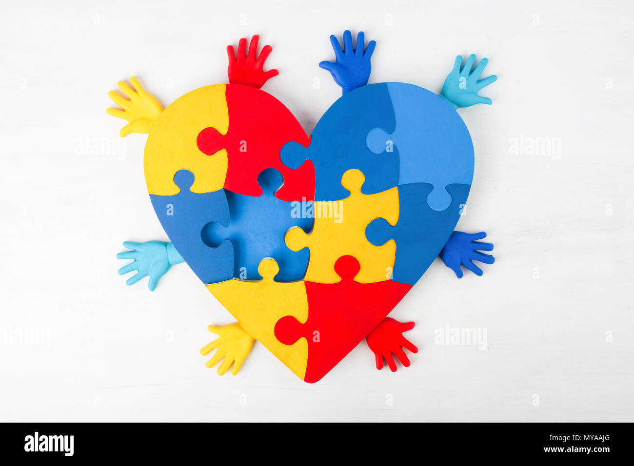 Puzzle cuore supporto mani di sensibilizzazione sull'autismo Foto Stock