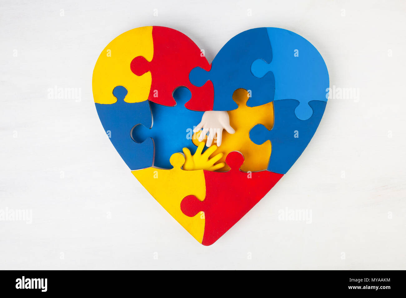 Puzzle cuore supporto mani di sensibilizzazione sull'autismo Foto Stock