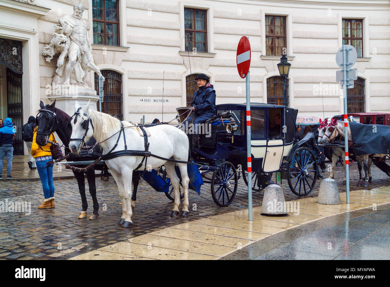 Vienna, Austria - 22 Ottobre 2017: carrelli tradizionali con i cavalli in attesa per i turisti nella piazza del Palazzo Imperiale Foto Stock