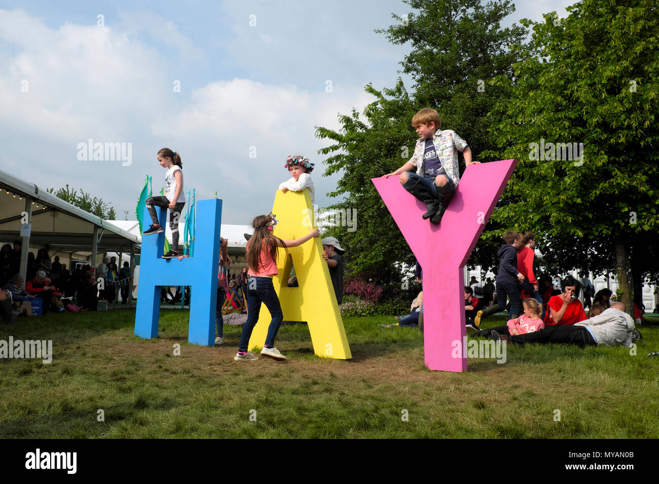 Bambini I bambini giocando arrampicata su Hay Festival cartello fuori dal tendone tenda a 2018 book festival in Hay-on-Wye Wales UK KATHY DEWITT Foto Stock