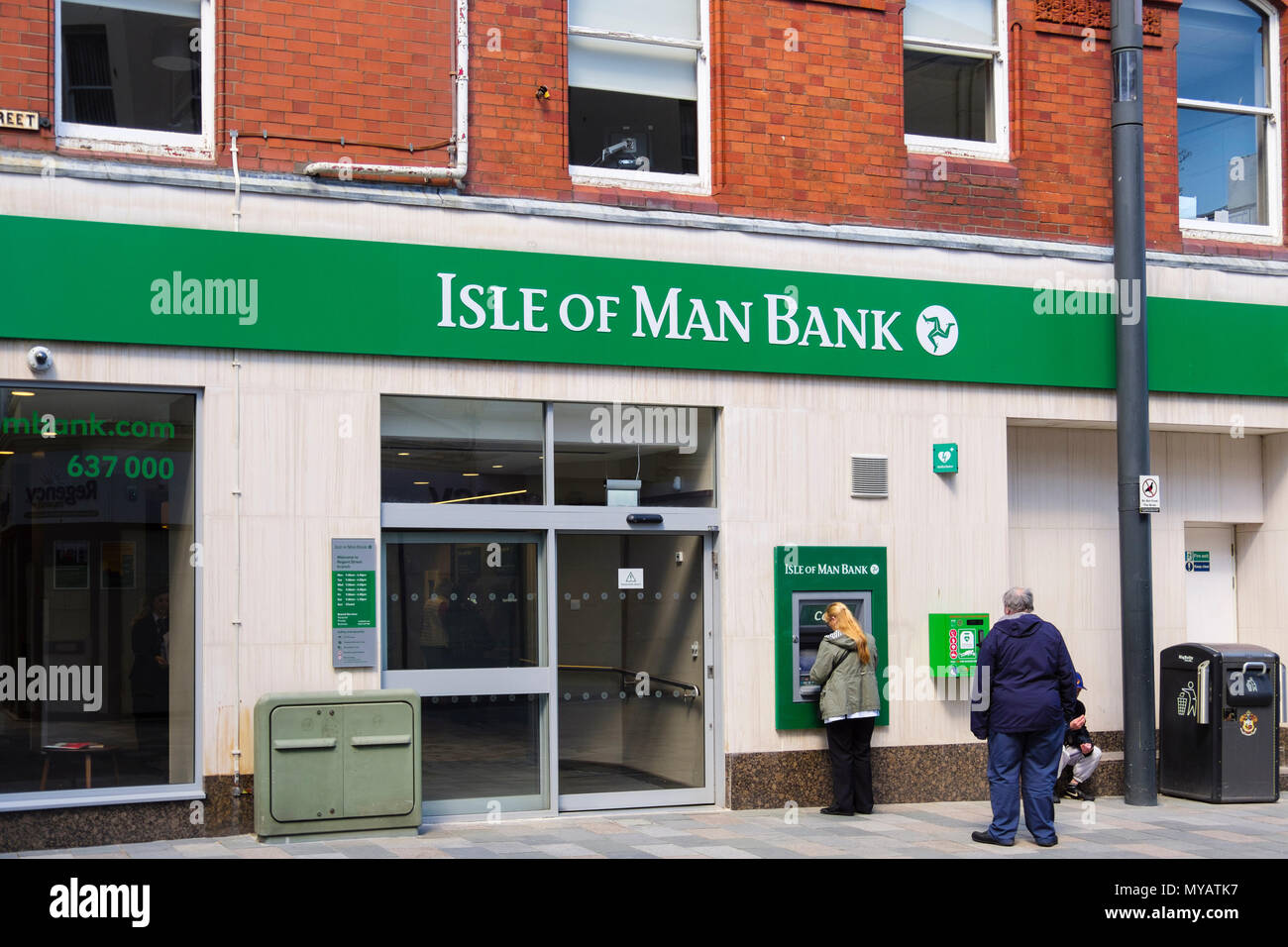 Le persone che usano un bancomat ATM al di fuori dell Isola di Man filiale di banca in Douglas, Isola di Man e Isole britanniche Foto Stock