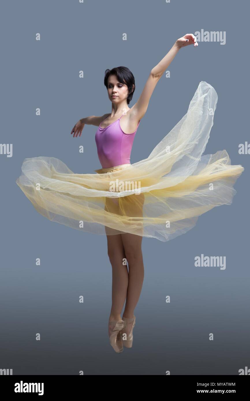 La ballerina è dancing in studio su sfondo grigio Foto Stock