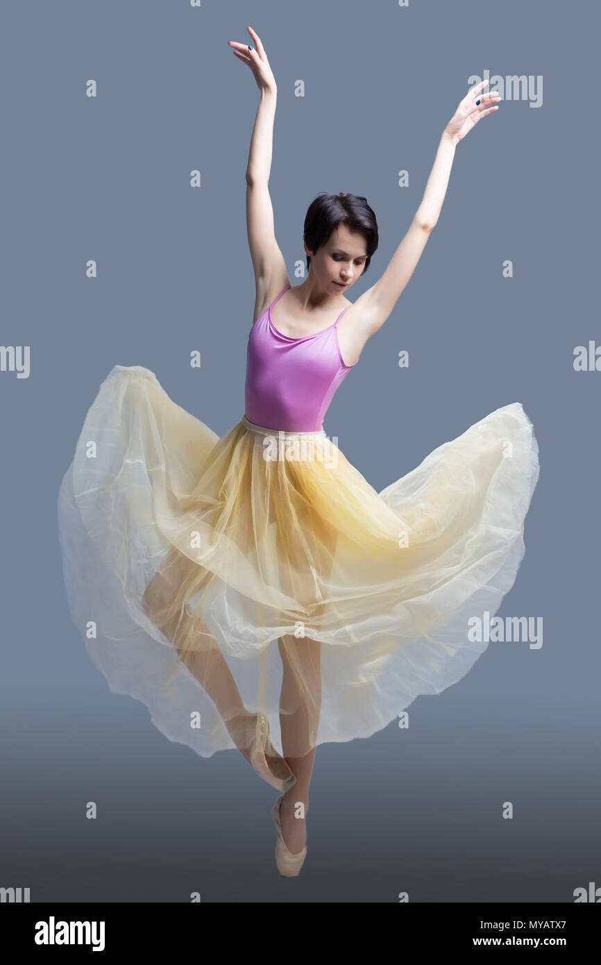 La ballerina è dancing in studio su sfondo grigio Foto Stock
