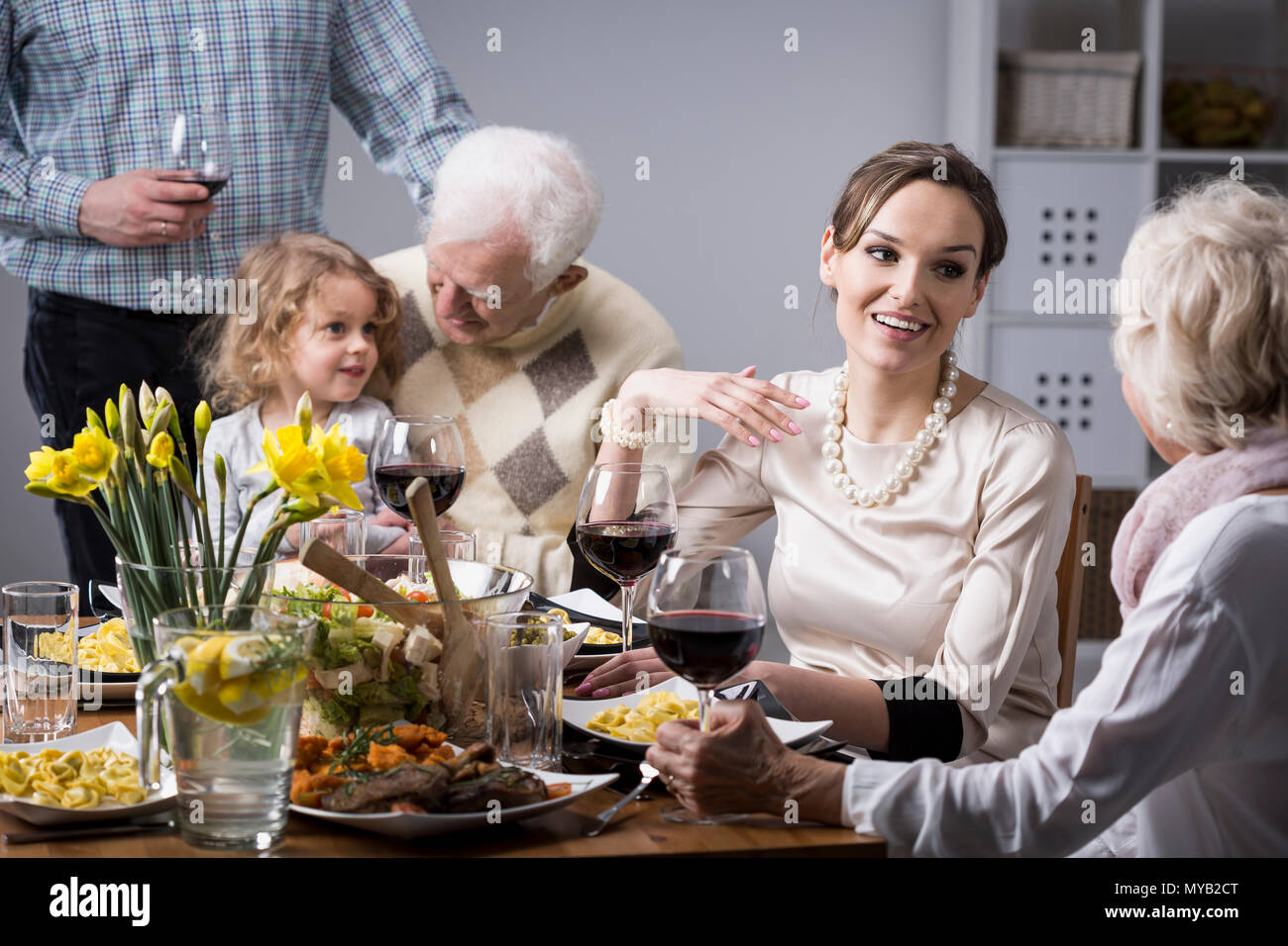 Le persone felici durante la cena di famiglia, parlando e sorridente Foto Stock