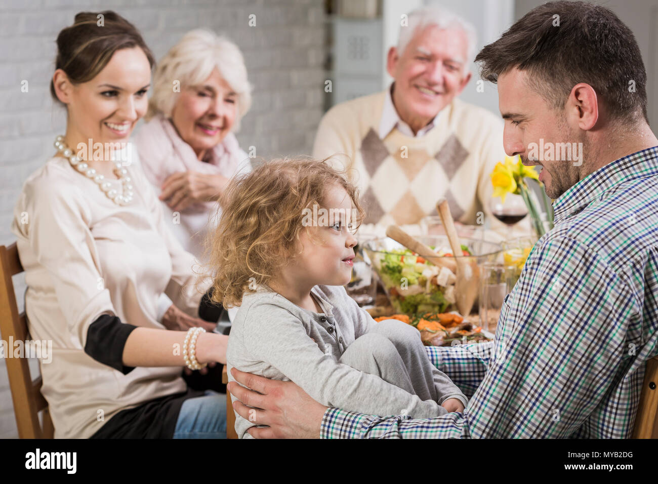 La famiglia felice durante la cena per celebrare la festa del papà, sorridente Foto Stock