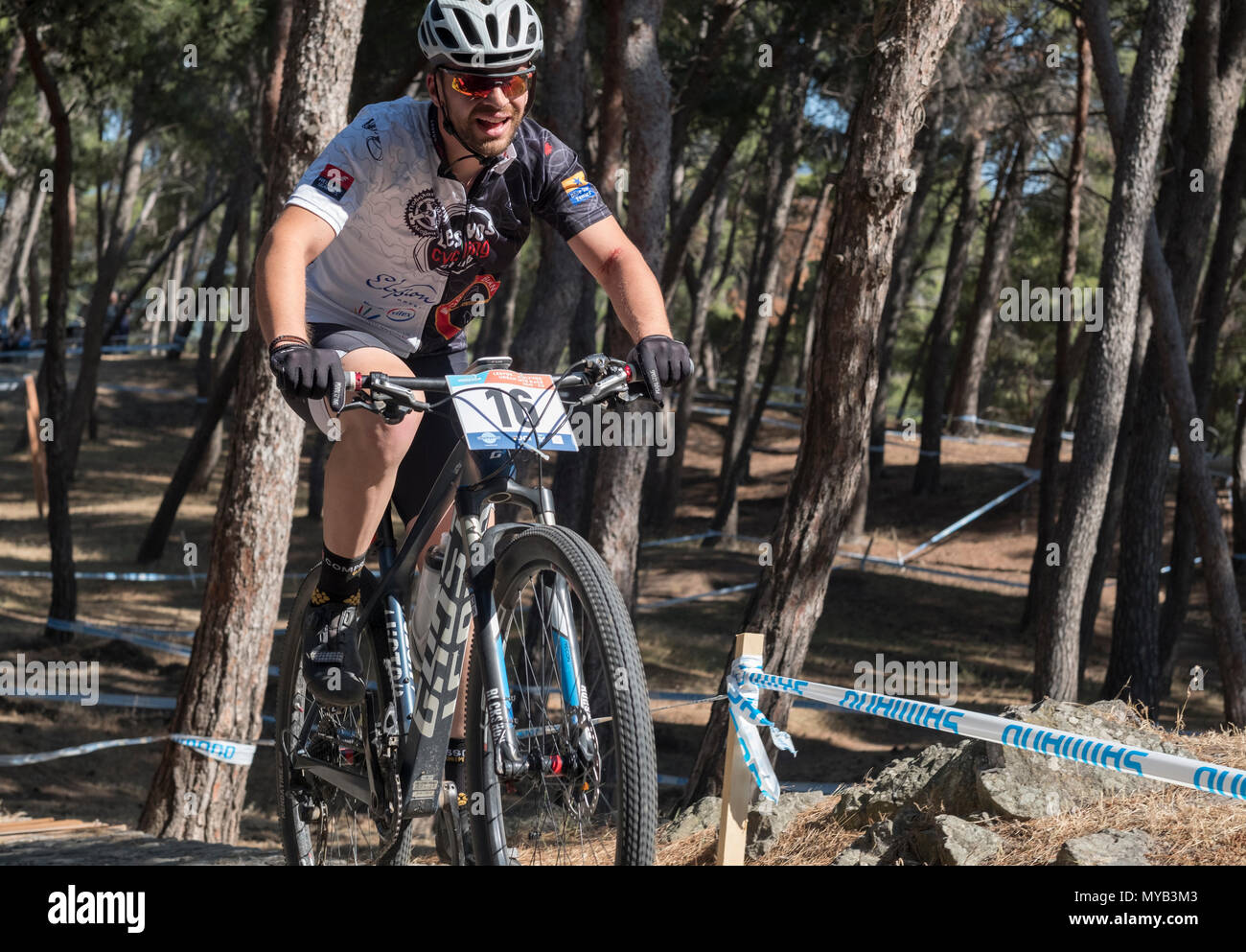 Greco ciclista maschio compete in una gara internazionale di mountain bike nel corso della foresta al di fuori del villaggio greco di molivos sull isola di Lesbo Foto Stock