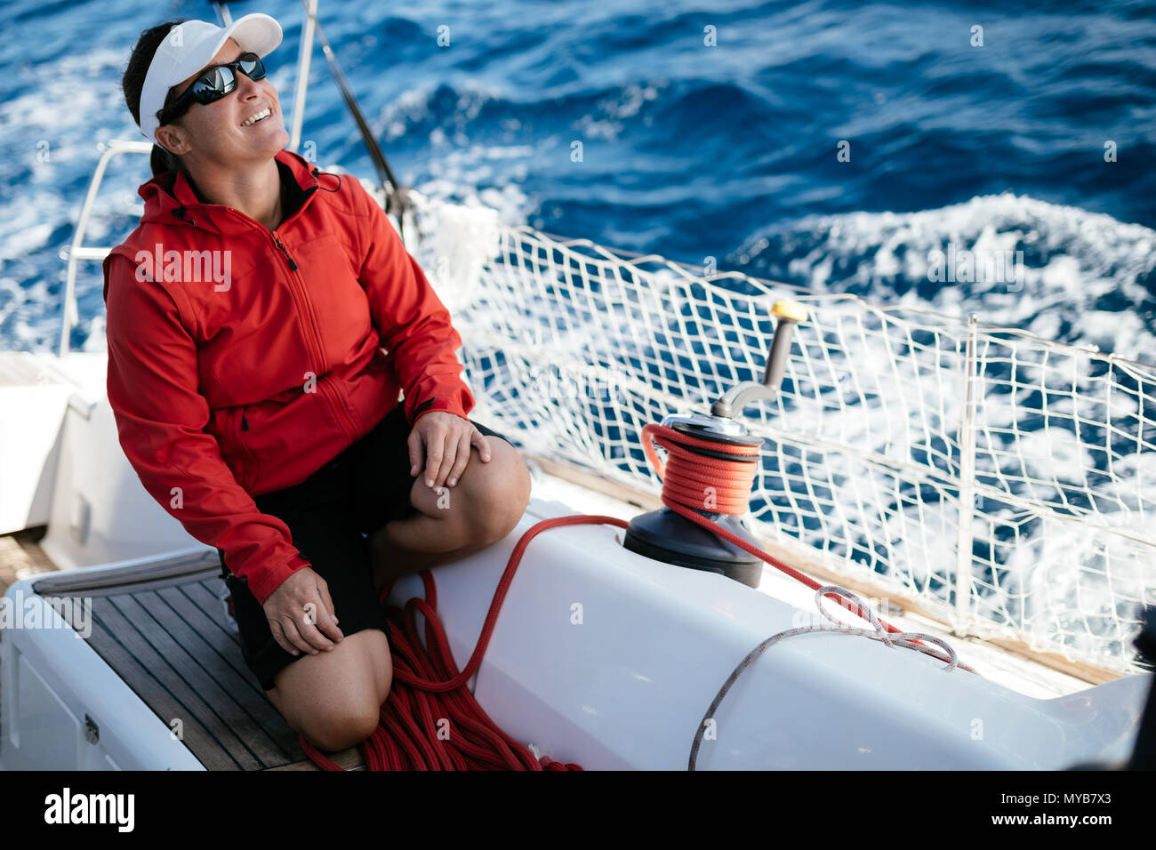 Attraente donna forte in barca a vela con la sua barca Foto Stock