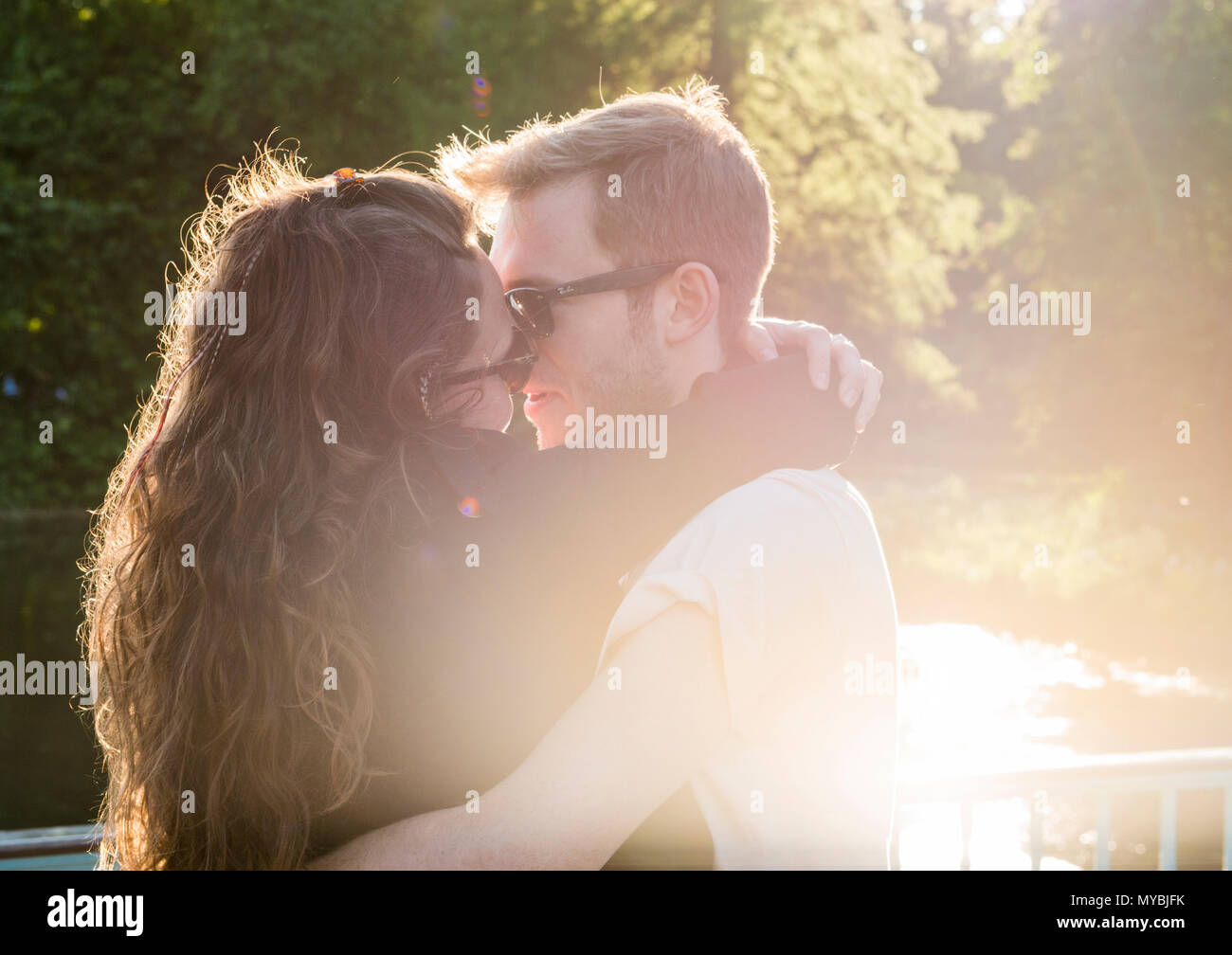 Giovane kissing al tramonto, St James Park, Londra, Inghilterra, Regno Unito Foto Stock