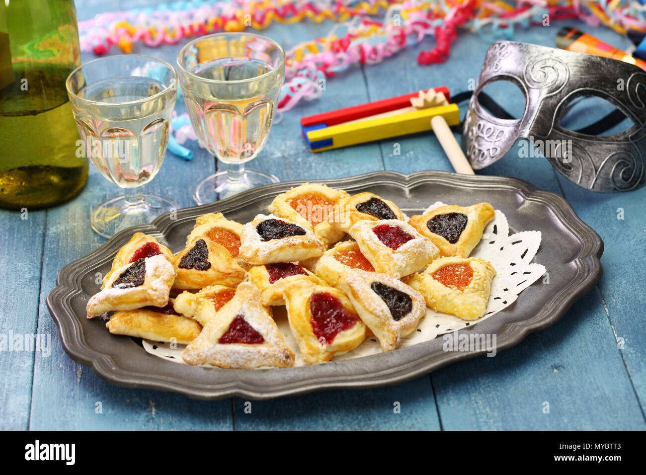 In casa hamantaschen cookie,noise maker e maschera, per felice Purim ebraico partito per le vacanze Foto Stock