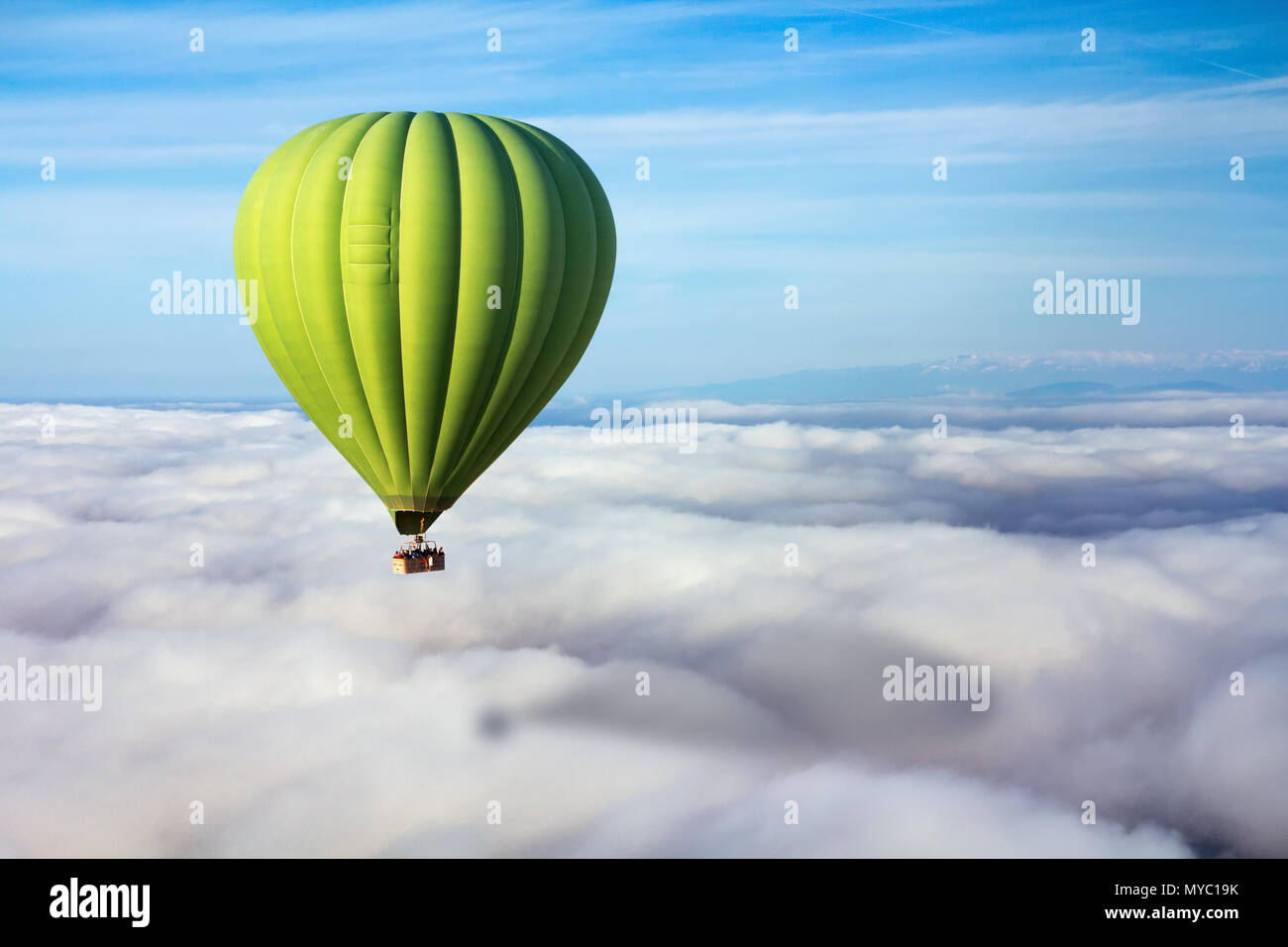 Un solitario verde mongolfiera galleggia sopra le nuvole. Concetto di leader, il successo, la solitudine, la vittoria Foto Stock