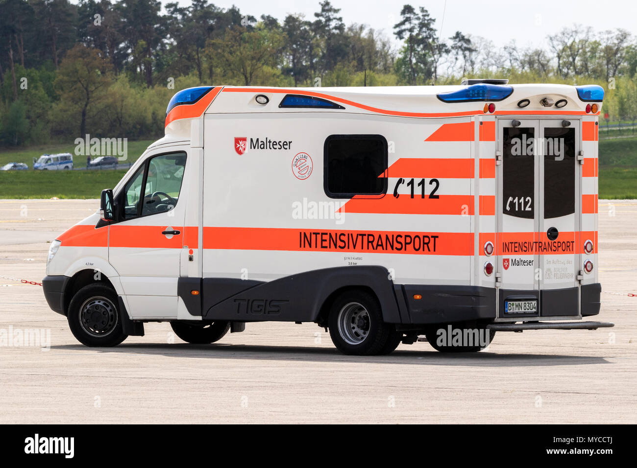 Berlino, Germania - Apr 27, 2018: Malteser mediche di emergenza ambulanza del veicolo in servizio all'aeroporto Berlin-Schonefeld. Foto Stock