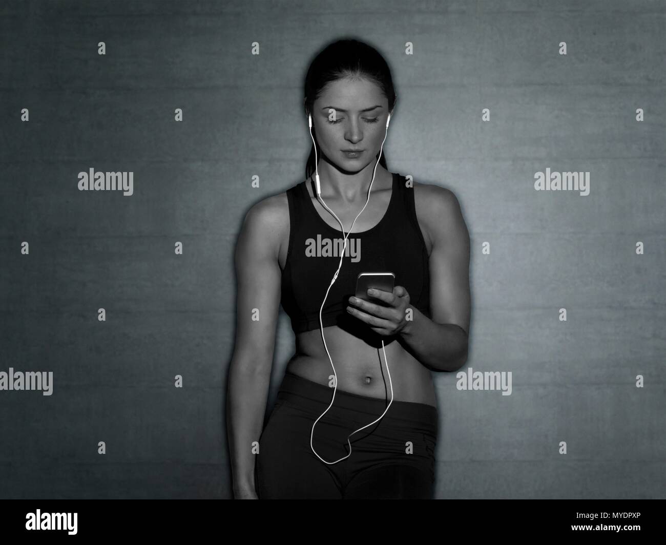 Giovane donna in sport top con lettore mp3, ritratto. Foto Stock