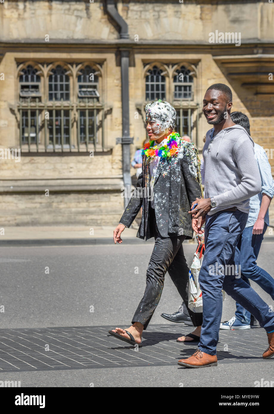 Università di Oxford, Inghilterra. Il 6 giugno 2018. Un maschio di studente presso l università di Oxford, ricoperto di schiuma e con una ghirlanda di fiori sulle spalle, passeggiate lungo la High Street per celebrare la sua finitura esami finali, una tradizione recente noto come 'distruggendo'. Credito: Michael Foley/Alamy Live News Foto Stock