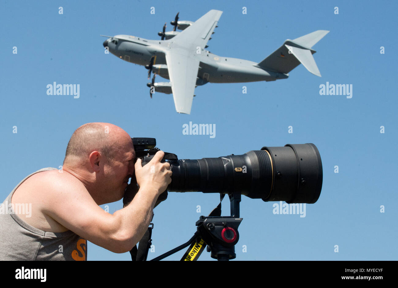 07 giugno 2018, Germania, Wunstorf: Planespotter Bernd Selbmann prende una foto come Luftwaffe Airbus A400M vola passato durante il tedesco della Bundeswehr 'Spotterday' a Wunstorf Airbase vicino Hannover. A Spotterday, 300 fotografi sono stati in grado di scattare foto della Bundeswehr aeromobile in azione. Foto: Julian Stratenschulte/dpa Foto Stock