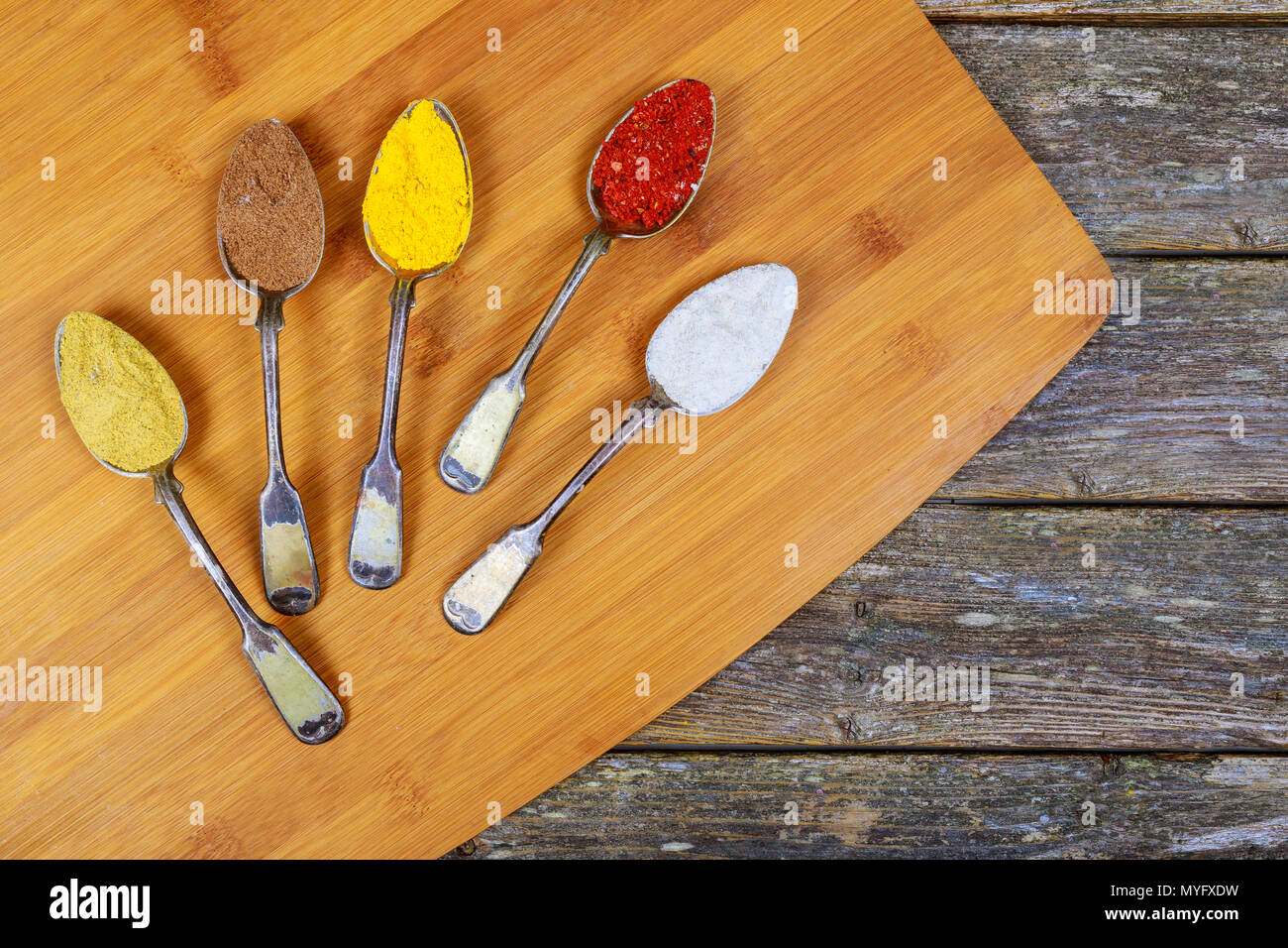 Selezione di spezie in polvere con semi in argento cucchiai lo sfondo Foto Stock