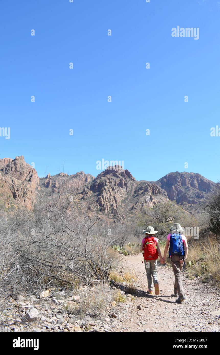 Due ragazze tenendo le mani ed escursionismo in Big Bend State Park, Texas Foto Stock