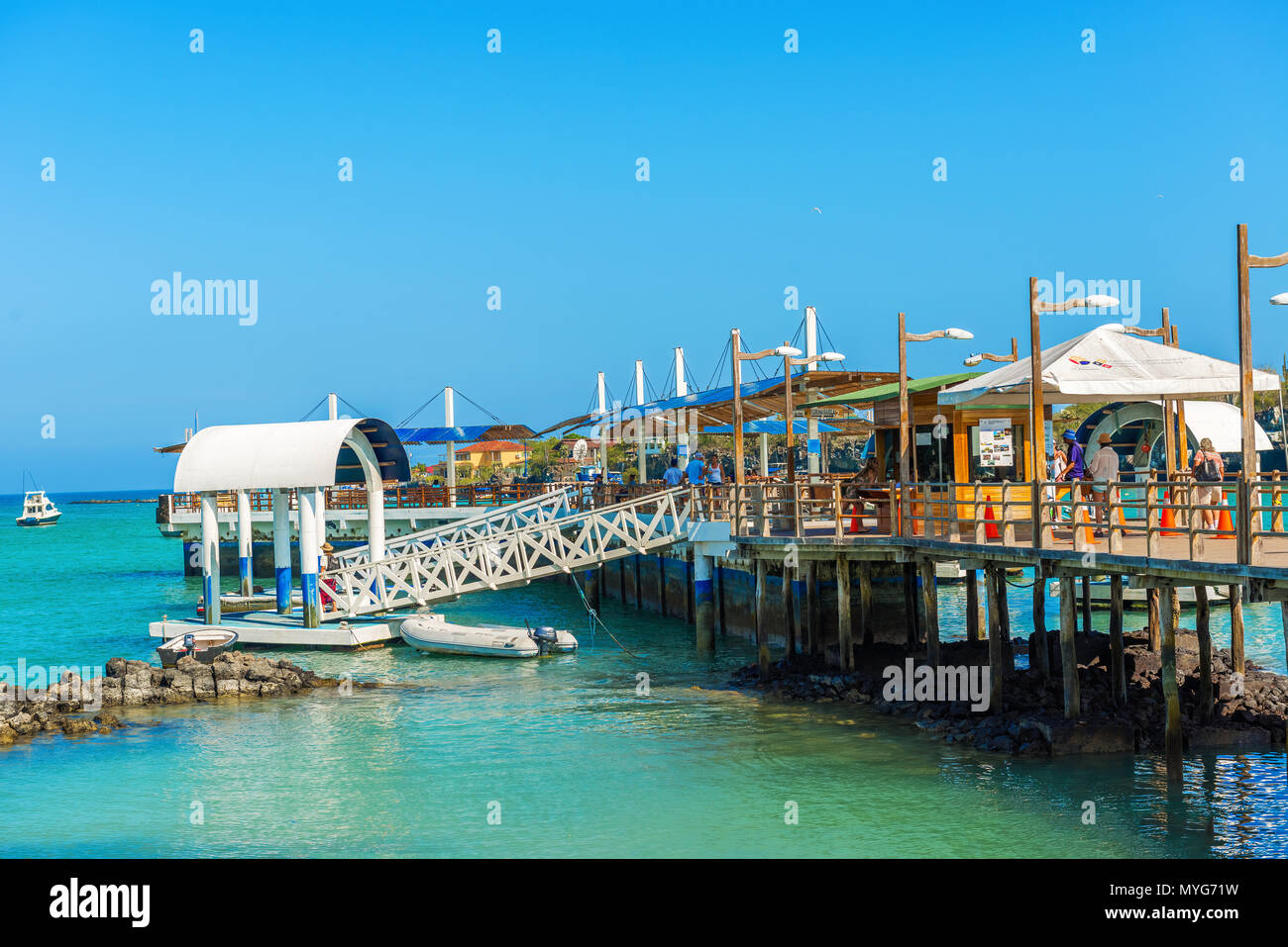 Puerto Ayora, Galapagos, Ecuador - Aprile 1, 2016: la gente camminare e in attesa per le barche sul molo di Puerto Ayora in Galapagos in una giornata di sole. Foto Stock