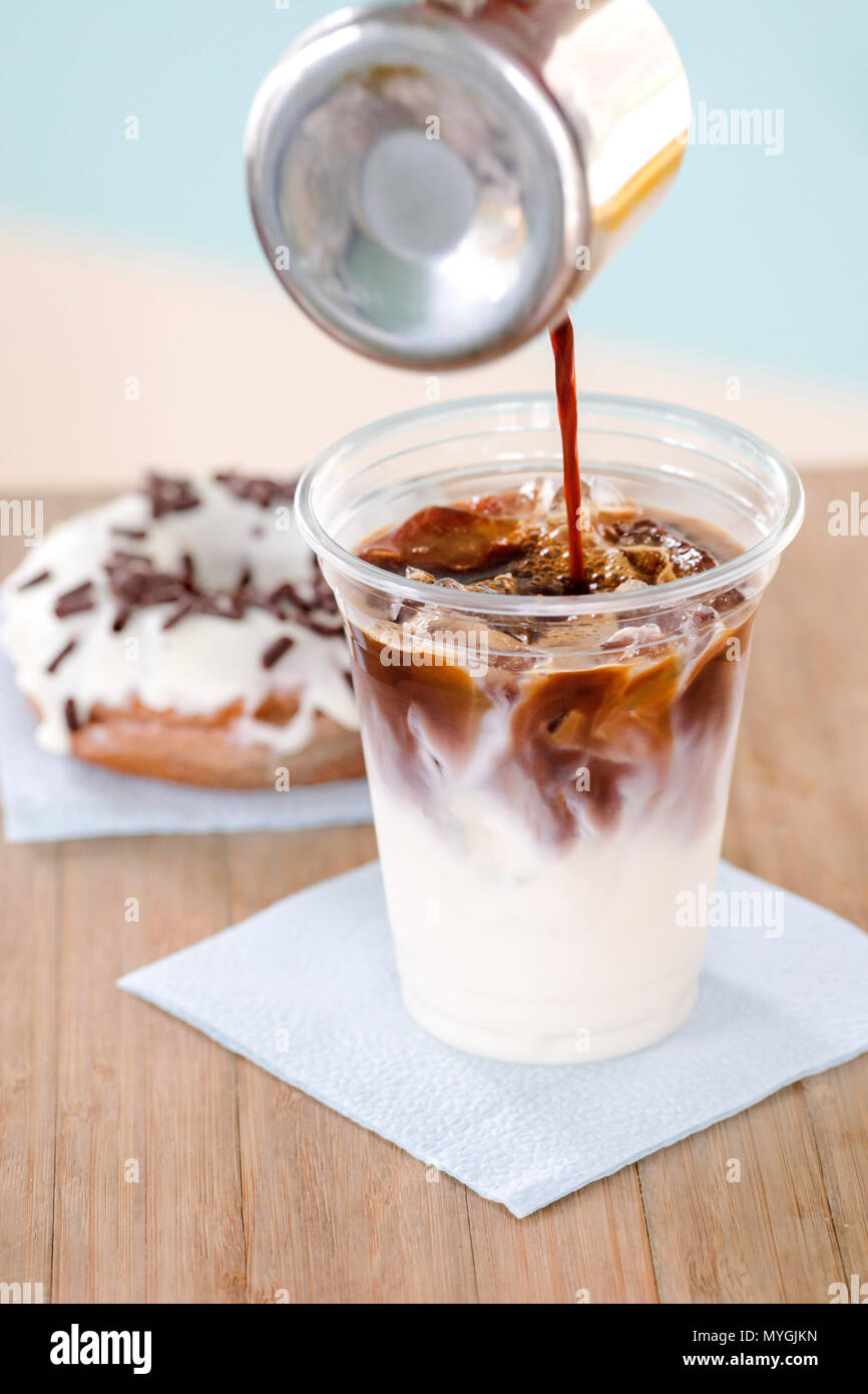 Versare il caffè nella tazza con gelato Foto Stock