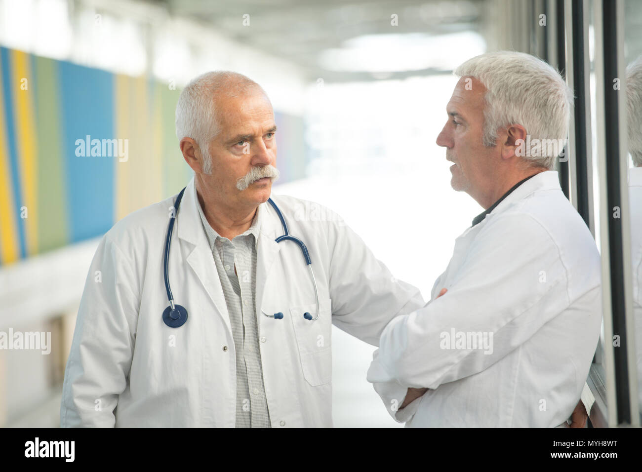 Due medici di sesso maschile avente una conversazione Foto Stock