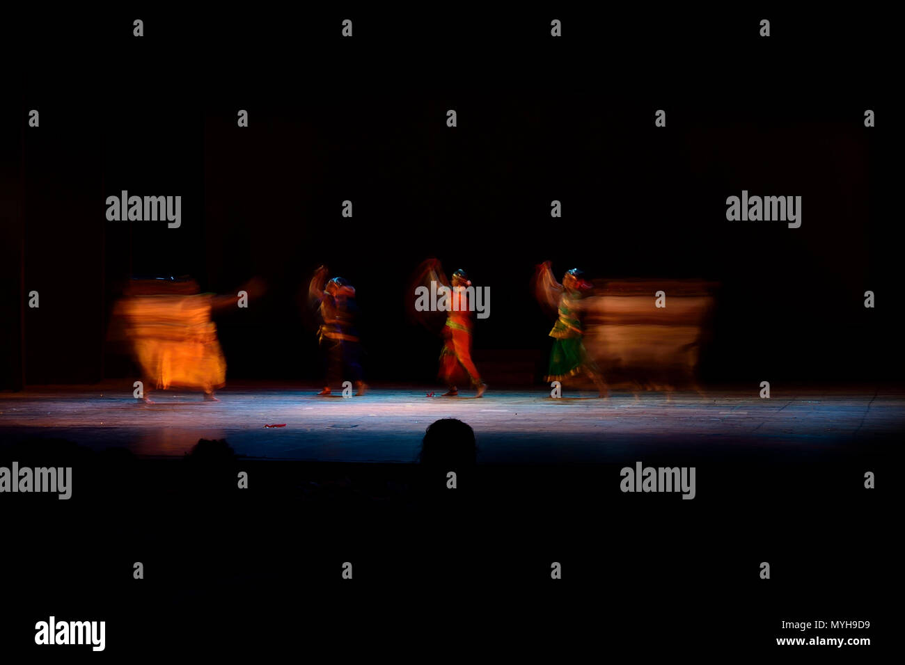 Un gruppo di persone che ballano sul palco su sfondo nero. Foto Stock