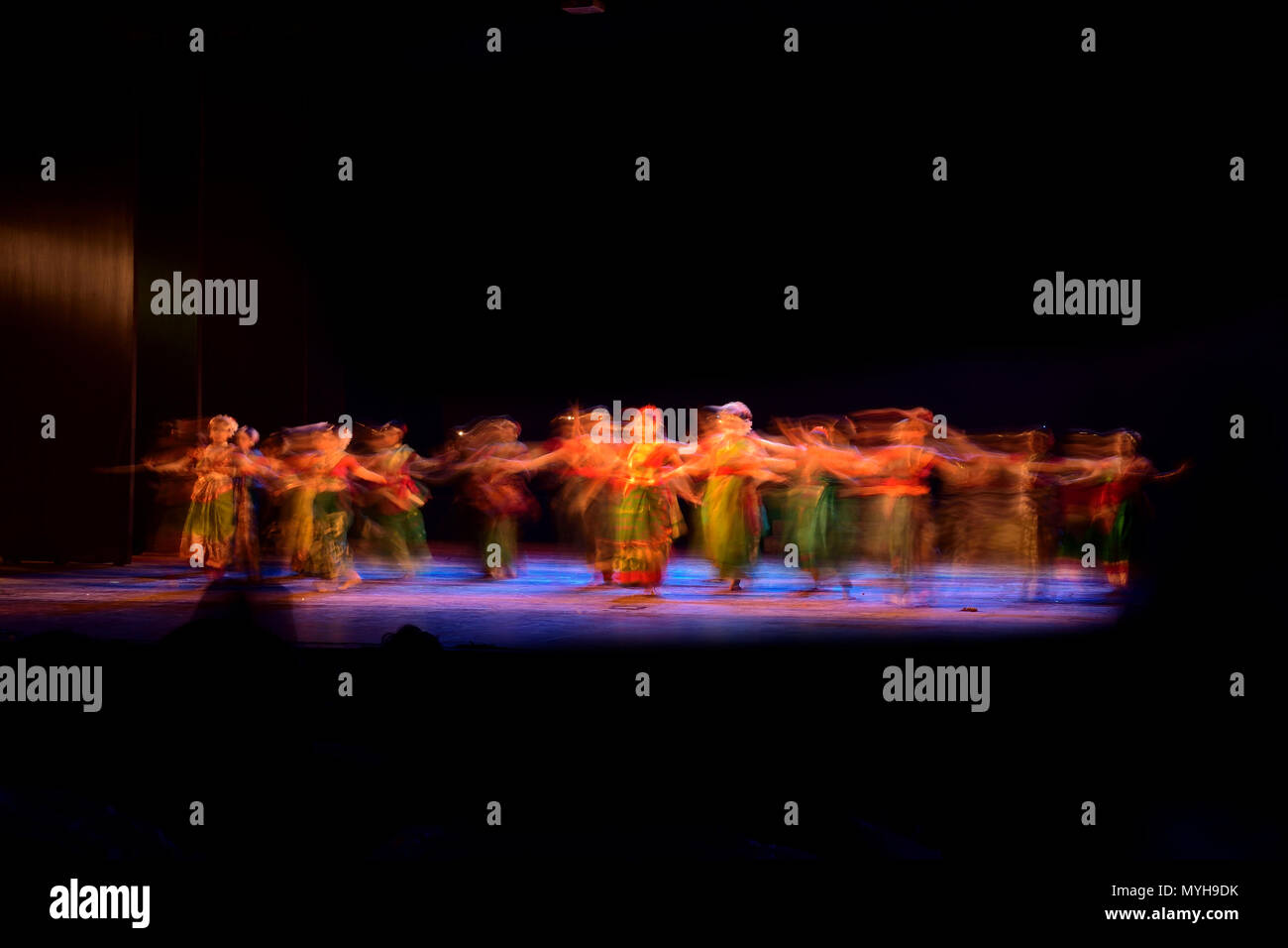 Un gruppo di persone che ballano sul palco su sfondo nero. Foto Stock