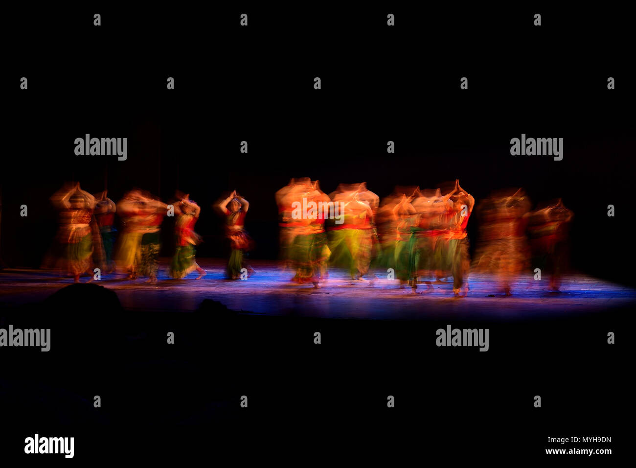 Un gruppo di persone che ballano sul palco su sfondo nero. Foto Stock