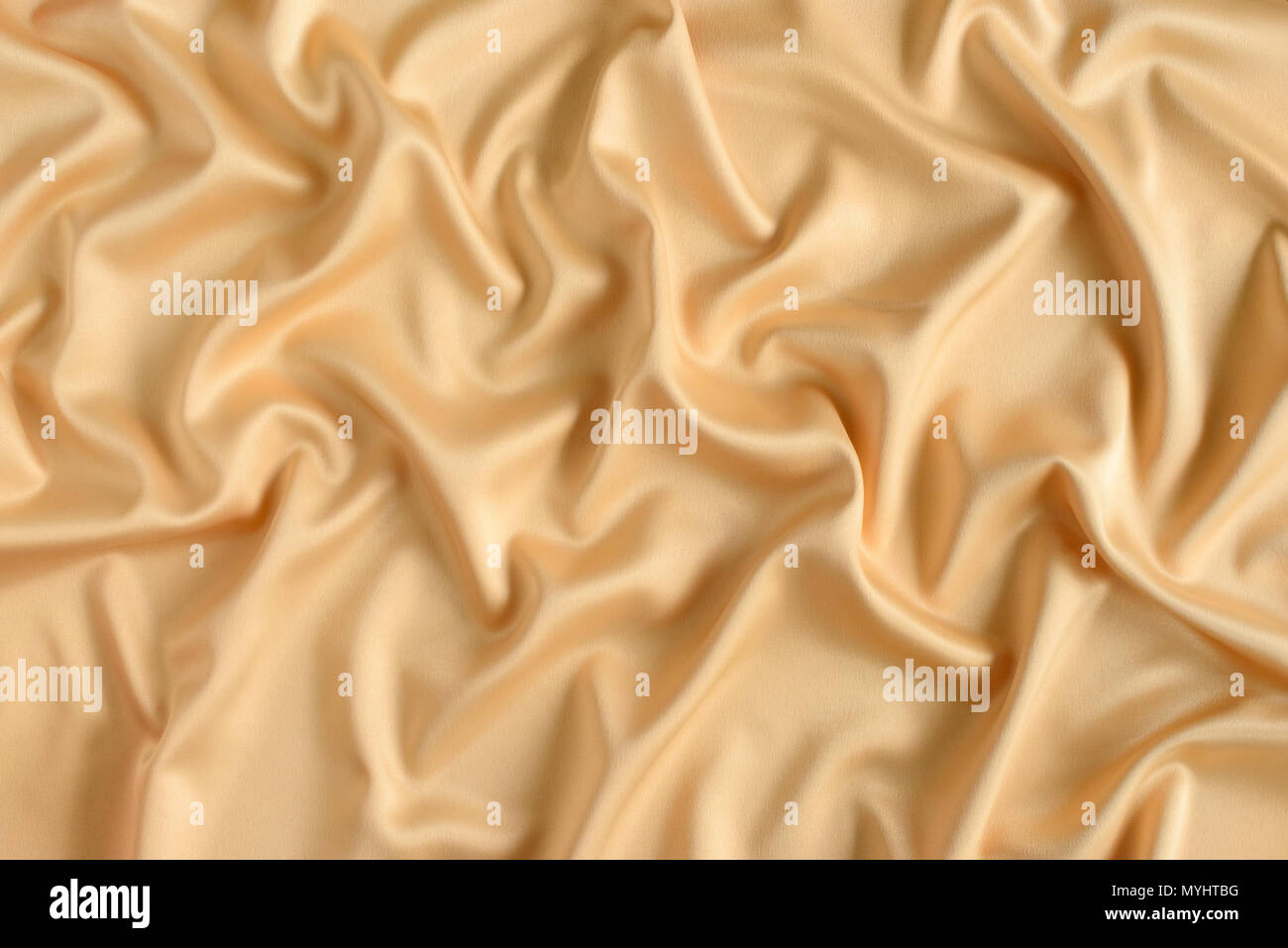 Close up di ondulazioni in color oro tessuto di seta. In raso sfondo tessili. Foto Stock