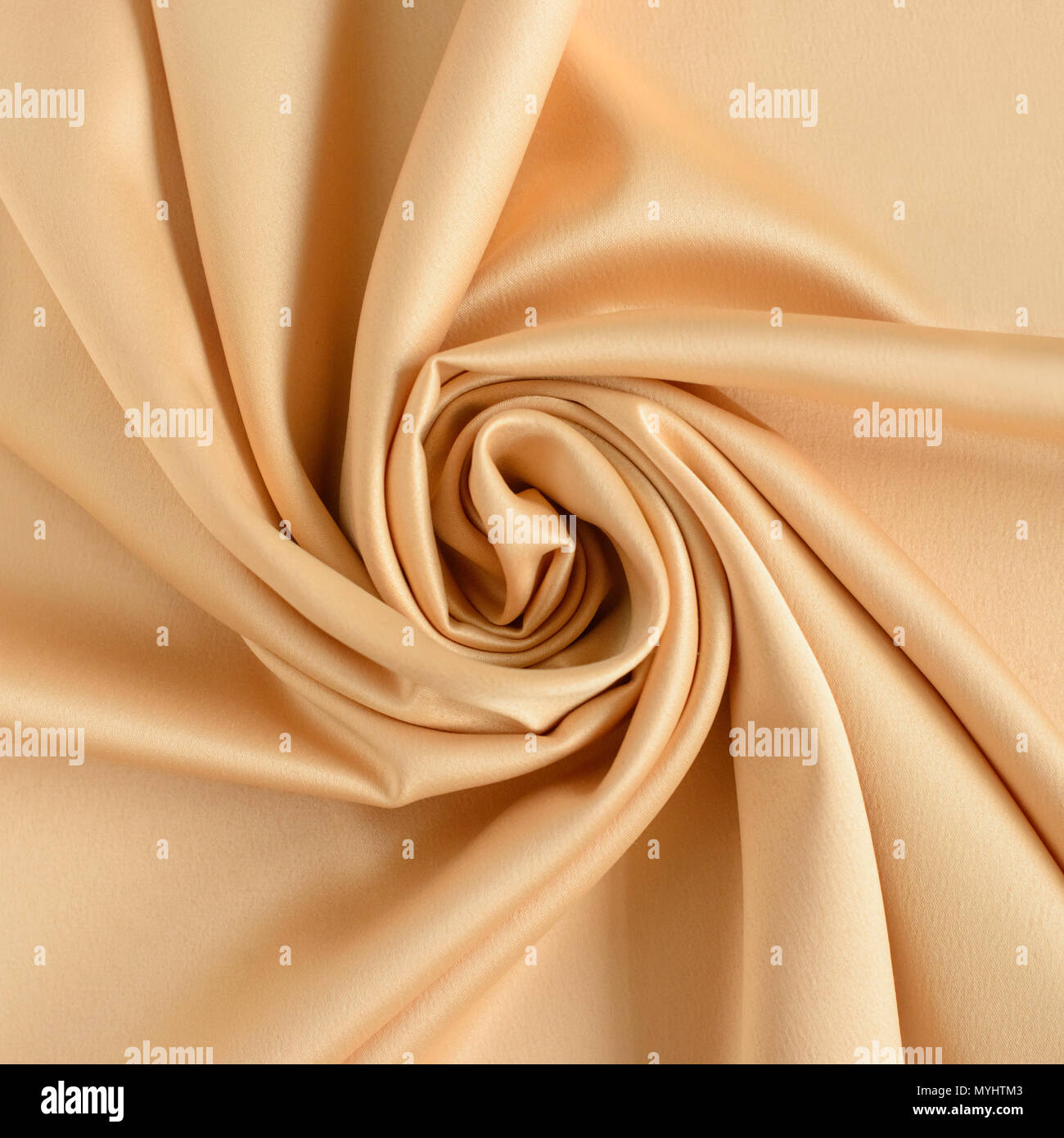 Close up di ondulazioni in forma di fiori di rose in color oro tessuto di seta. In raso sfondo tessili. Foto Stock