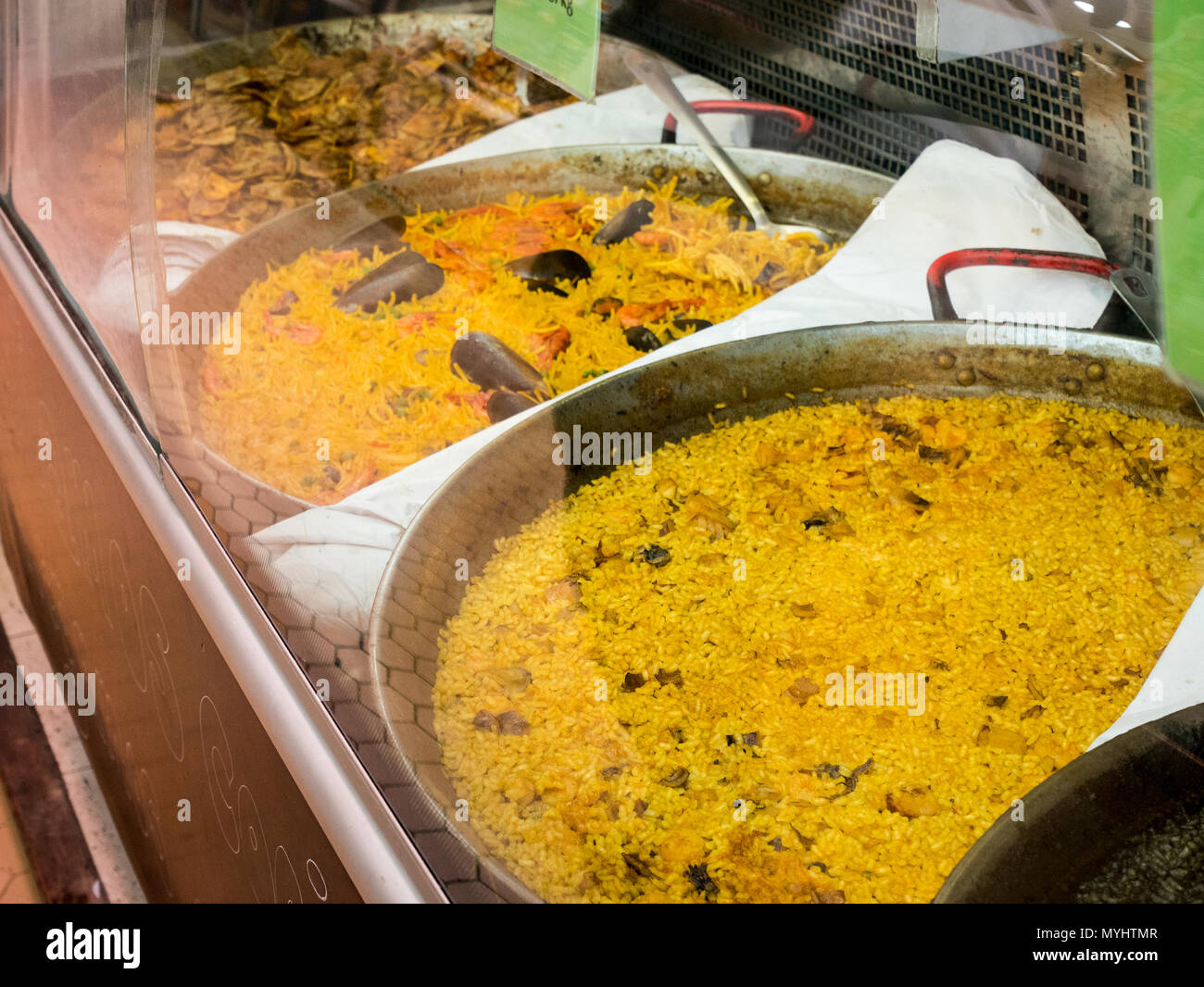 Enormi vasi con vari tipi di paella su un contatore al mercato centrale di Valencia, Spagna Foto Stock