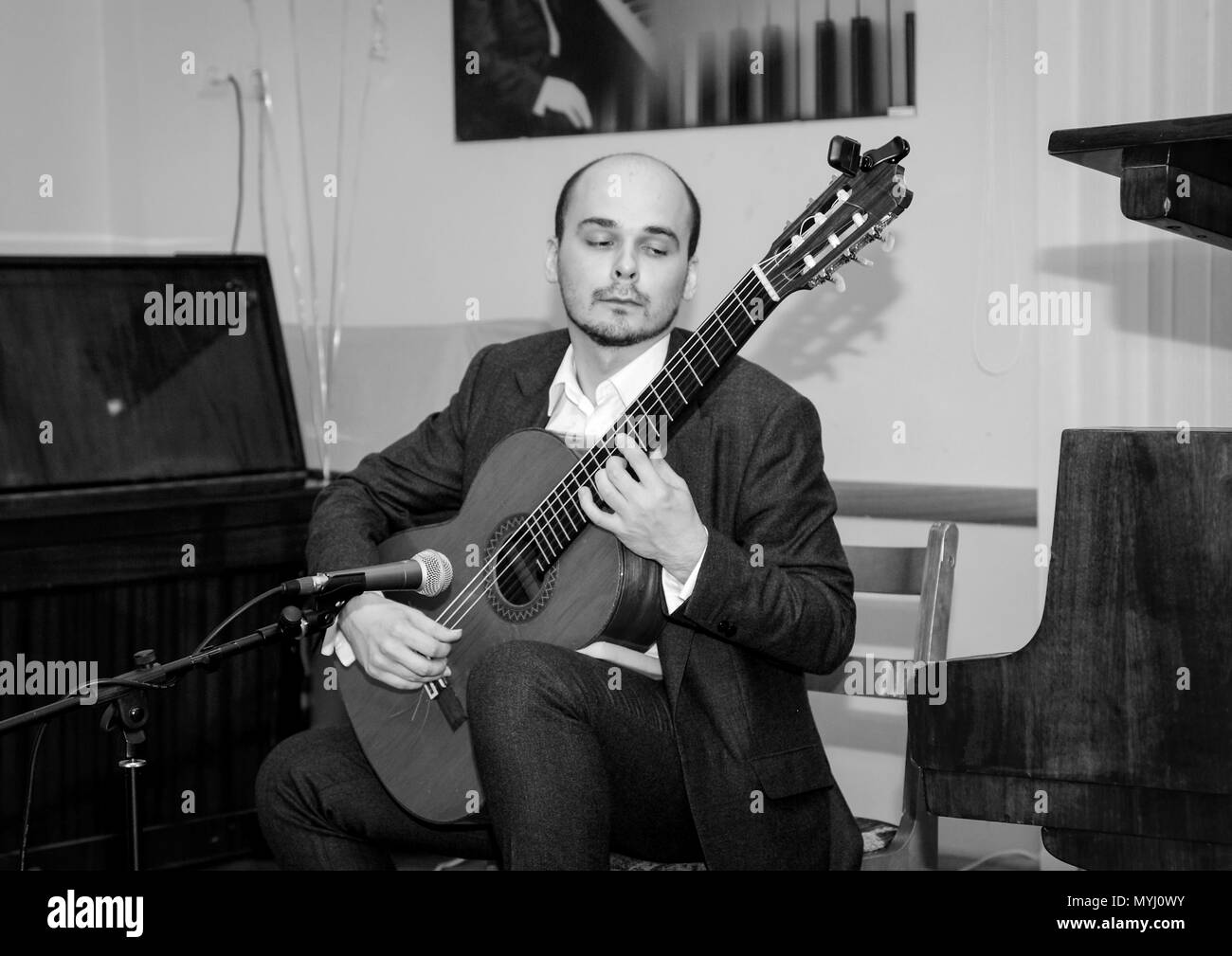 Foto in bianco e nero. Musicista con emozioni sul suo volto a suonare la chitarra. Foto Stock