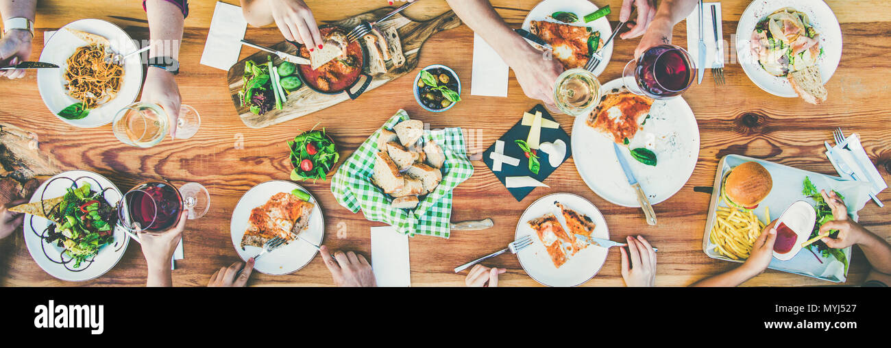 Mangiare e il concetto di tempo libero - gruppo di persone aventi la cena a tavola con i prodotti alimentari Foto Stock