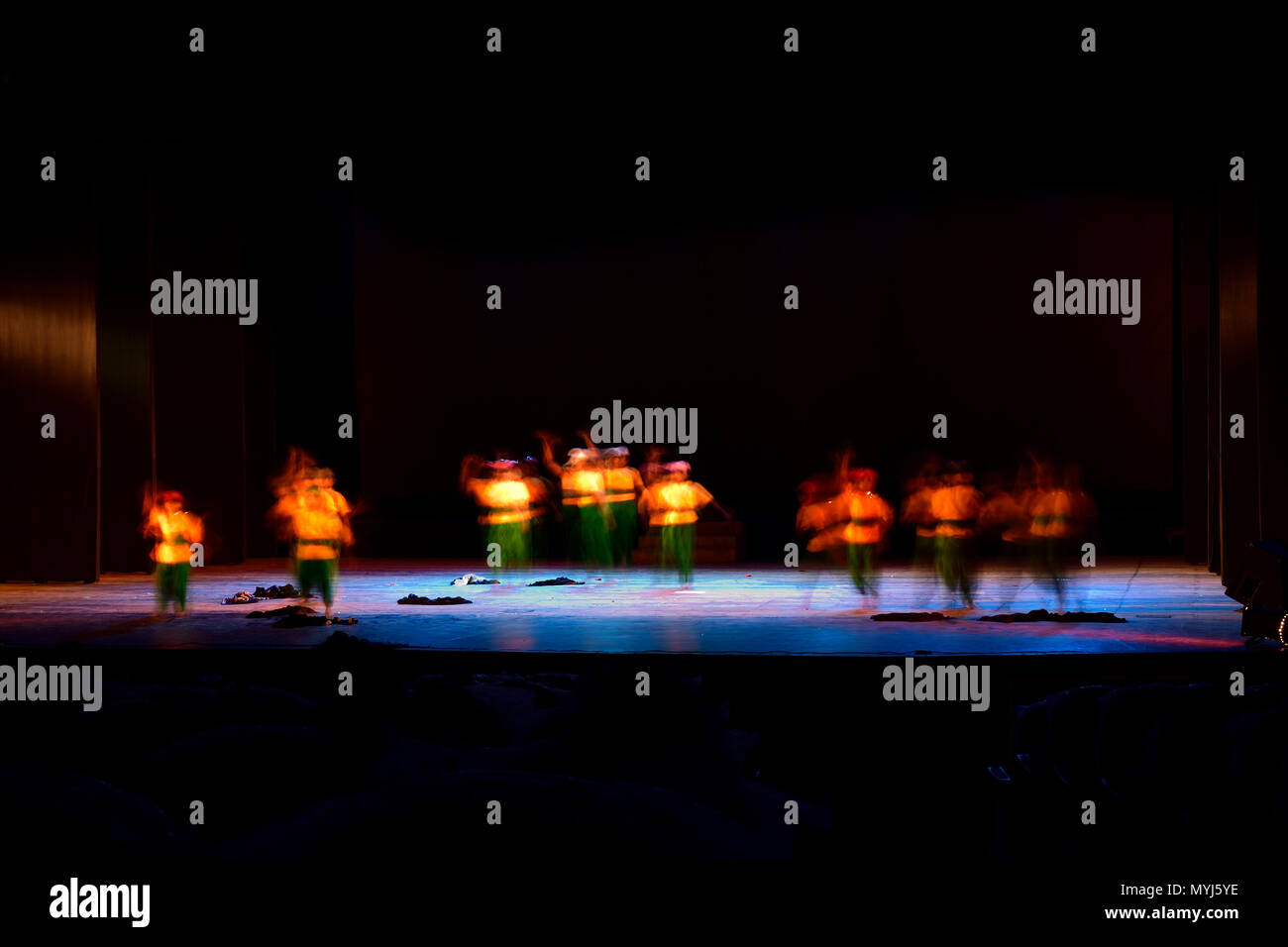Un gruppo di persone che ballano sul palco su sfondo nero. Foto Stock