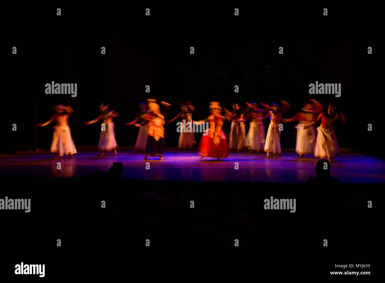 Un gruppo di persone che ballano sul palco su sfondo nero. Foto Stock