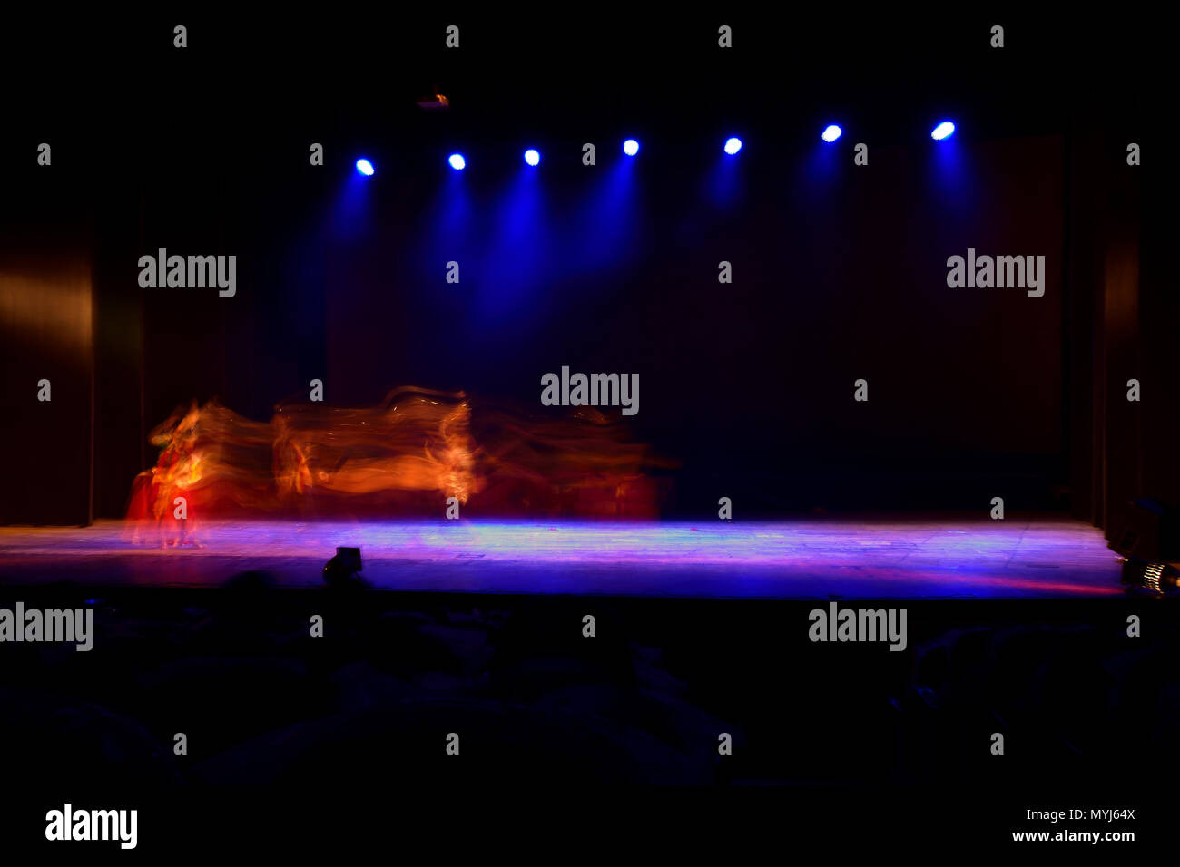 Un gruppo di persone che ballano sul palco su sfondo nero. Foto Stock