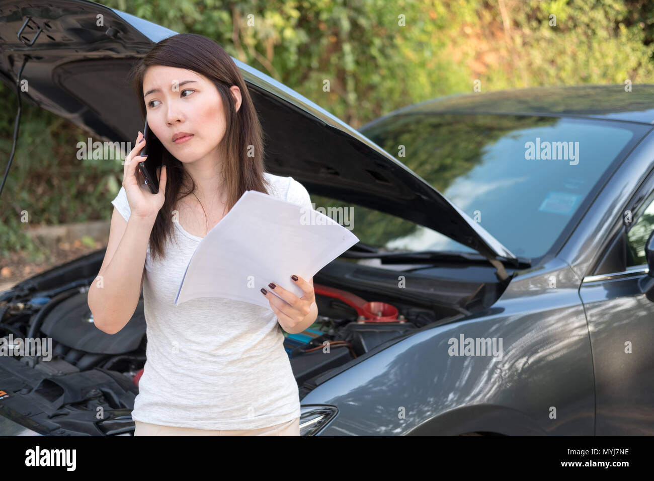 Asia giovane donna in piedi di fronte alla rottura di un auto, chiede aiuto,hanno bisogno di servizio di emergenza Foto Stock